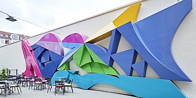Foto: Innenhof Einstein 28 mit farbiger Stahlplastik „Common Wall“