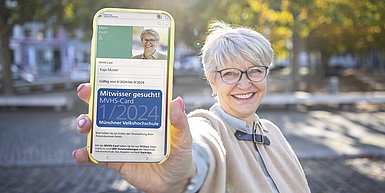ältere Frau mit MVHS-Card auf dem Smartphone