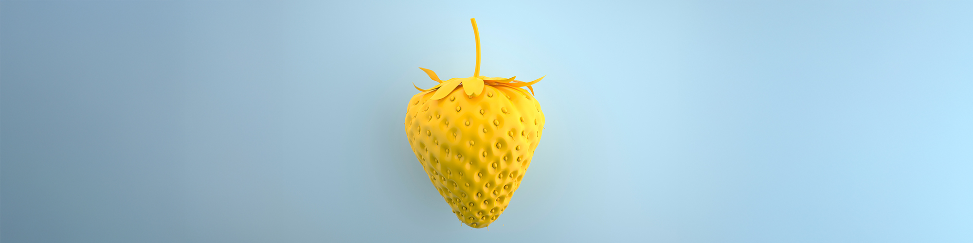 Foto: gelb eingefärbte Erdbeere vor blassblauem Hintergrund