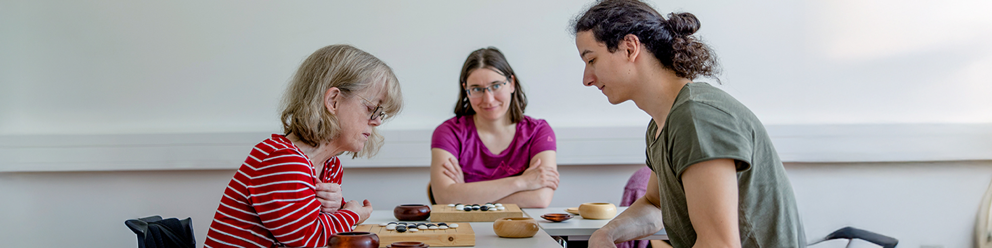 Teilnehmende lernen in einem Kurs das Brettspiel "Go"