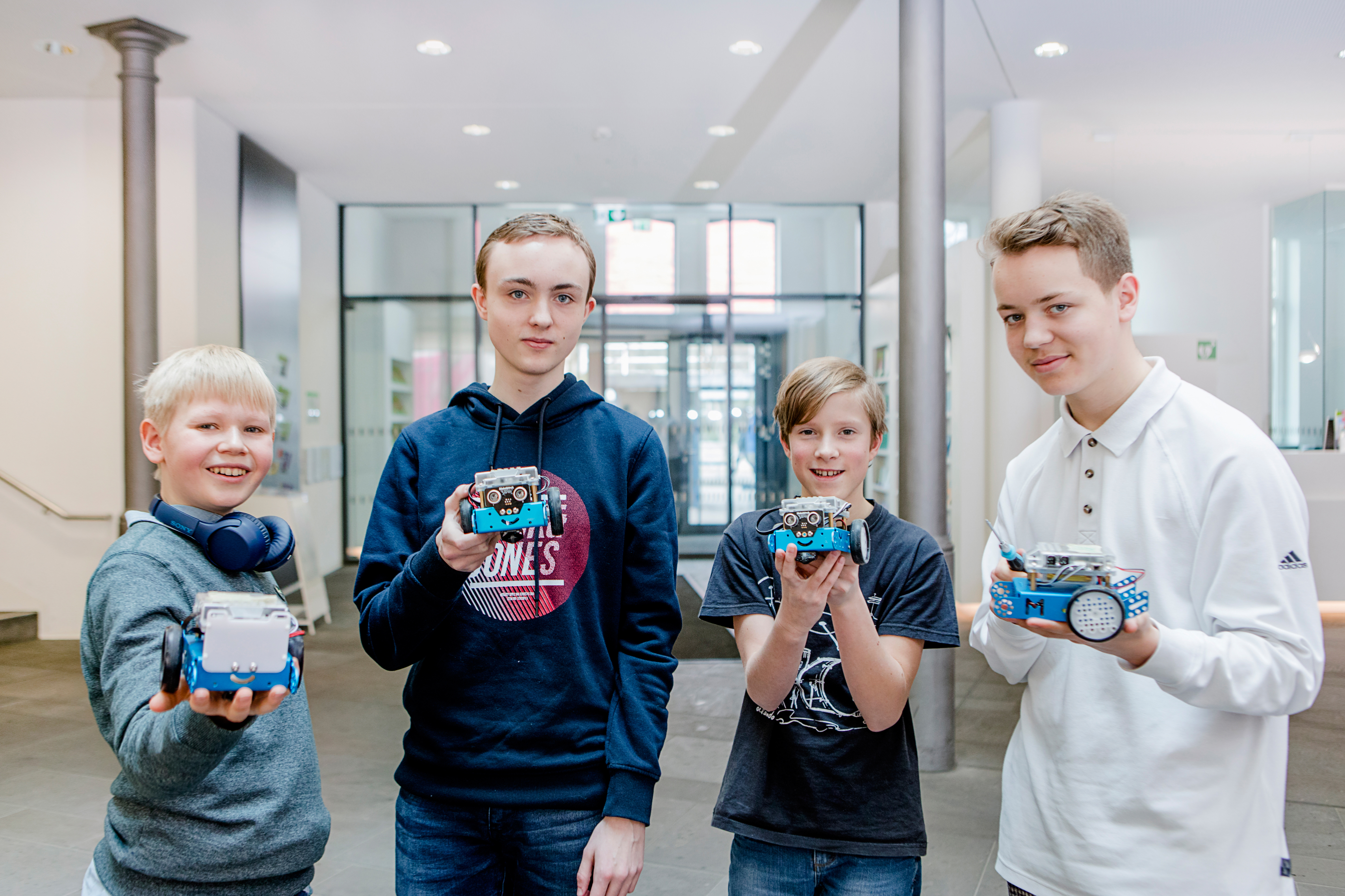 Foto: Vier Jungs halten ihre gebauten Roboter