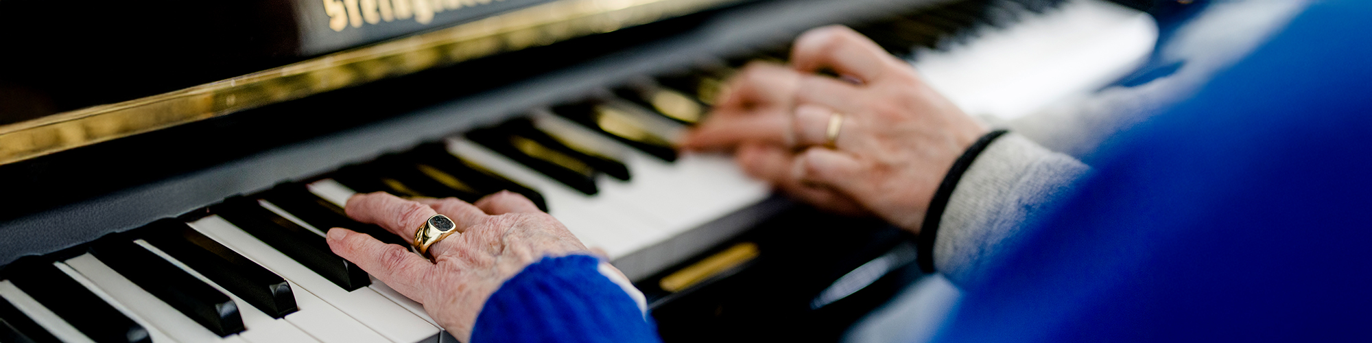 Gemeinsames Klavierspielen in einem Kurs für Seniorinnen und Senioren.