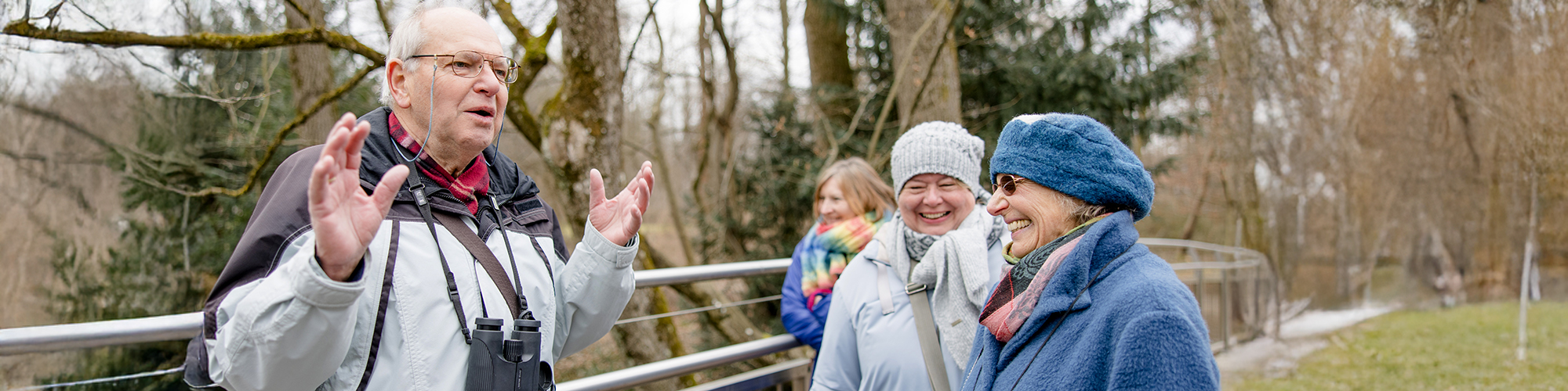 Interessierte Seniorinnen hören dem engagierten Dozenten bei einer Naturführung zu
