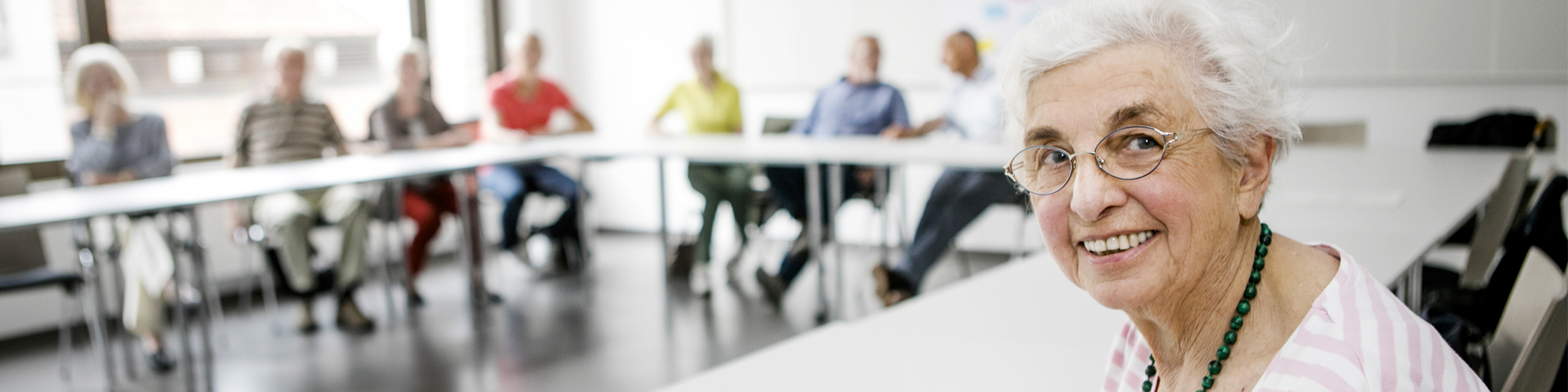 Ältere Teilnehmerin arbeitet konzentriert im Philosophiekurs