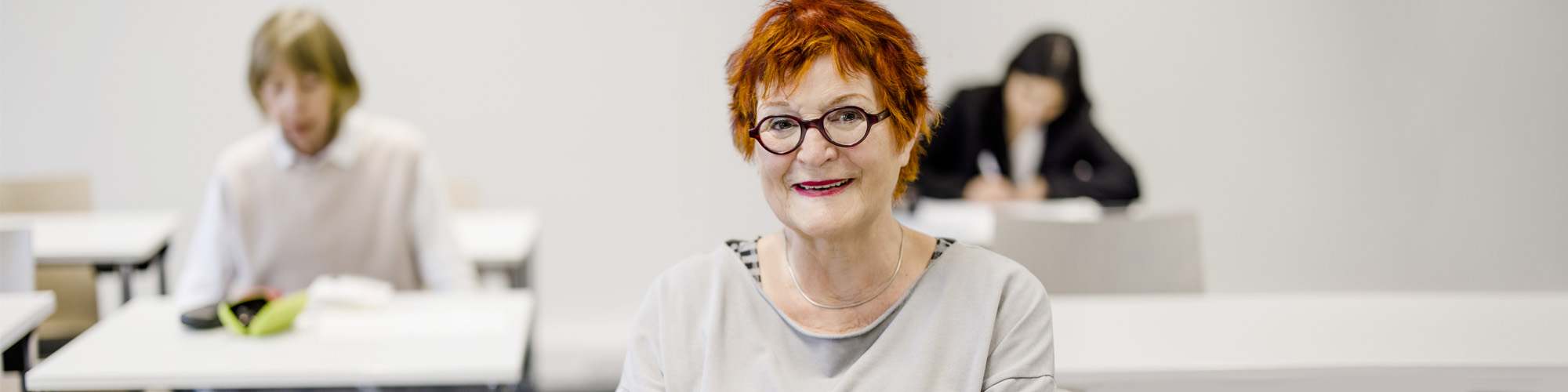 Ältere Teilnehmerin arbeitet konzentriert im Kurs.