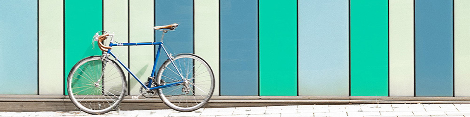 Fotografie eines Fahrrads vor bunt gestreifter Fassade.