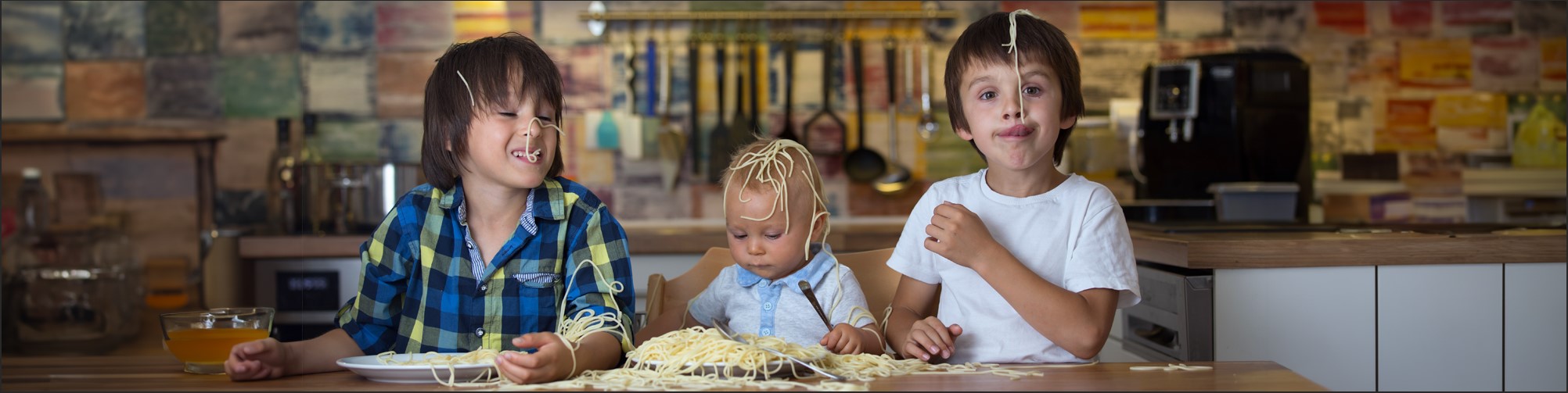 Kinder spielen mit Spaghetti beim Essen